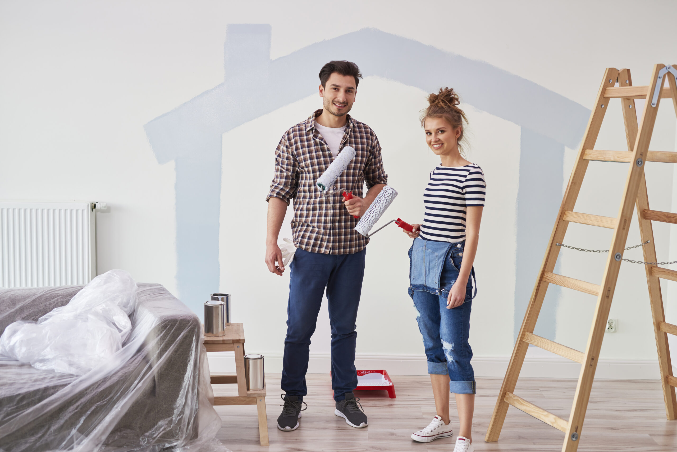 portrait of couple painting the interior wall in new apartment portrait of couple painting the interior wall in new apartment